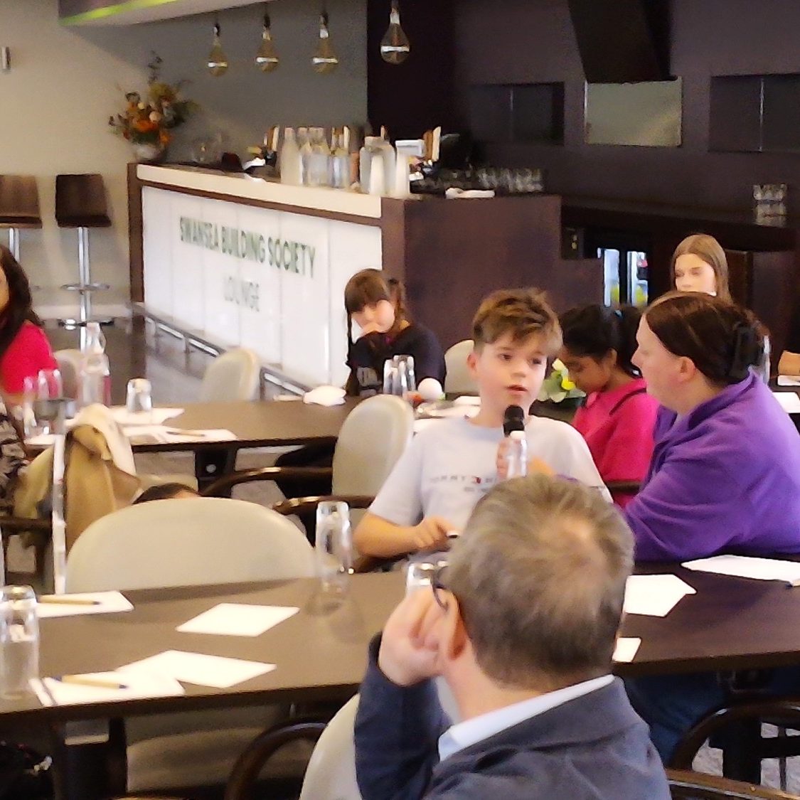 Young attendees engaged in discussion at a conference or workshop.